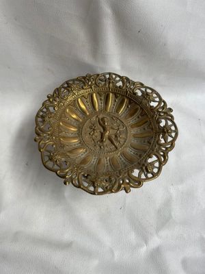 un gros plan d'une assiette dorée posée sur une nappe blanche