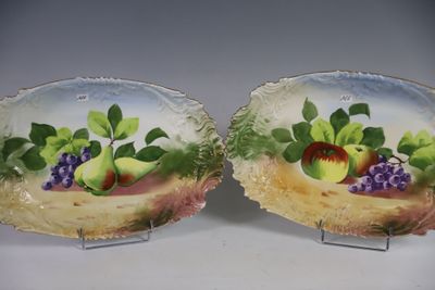 deux assiettes sur lesquelles sont peints des fruits, posées sur une table