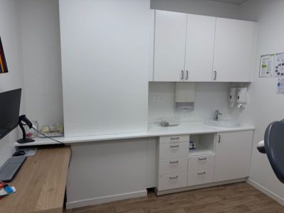 a desk with a computer and a chair in a room
