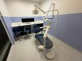 a dentist ' s chair in the corner of the room