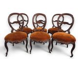 a set of four chairs with a brown upholstered upholstered seat
