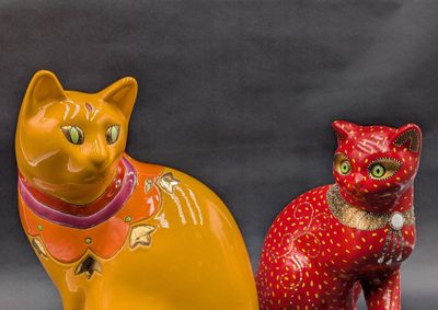 two figurines of cats sitting next to each other