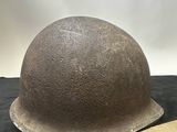 an old helmet is sitting on a table with a cloth strap around it