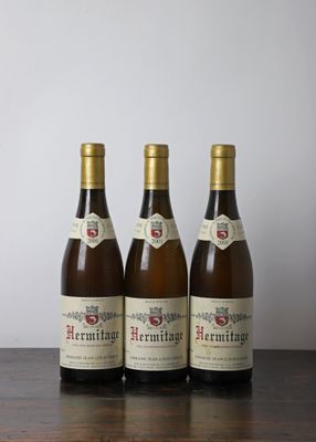 trois bouteilles de vin posées sur une table en bois