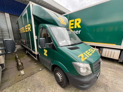 un camion vert garé devant un immeuble
