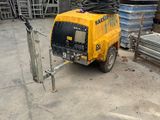 a yellow truck that is parked in front of a pile of metal