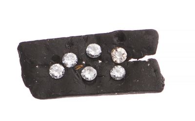 un petit morceau de tissu noir orné de cinq diamants