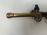 an old brass gun mounted on a wall with a man sitting on top of it