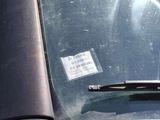 a sticker on the windshield of a car that is parked in a parking lot