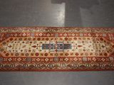 an image of a long rug on a floor with a cat sitting on the floor