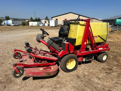 an image of a red lawn mower parked in the dirt