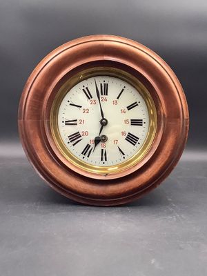 horloge avec des chiffres romains sur le cadran, sur un fond gris