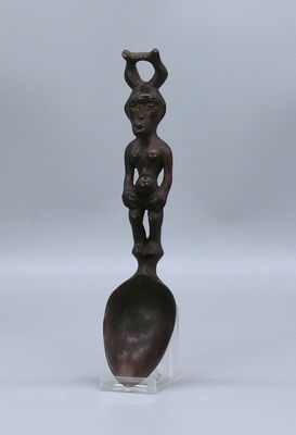 une statue en bronze représentant une femme tenant un bébé sur une cuillère