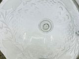 a clear glass bowl with a floral design on it