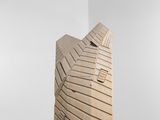 une sculpture en bois posée sur une table, avec un mur blanc en arrière-plan