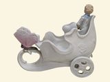 a figurine of a baby in a carriage with a butterfly on it
