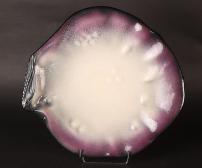 a close up of a purple and white plate on a black surface