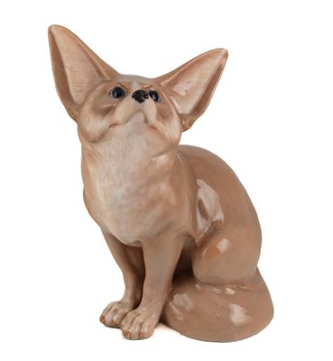 une petite figurine en céramique représentant un chat assis sur une surface blanche
