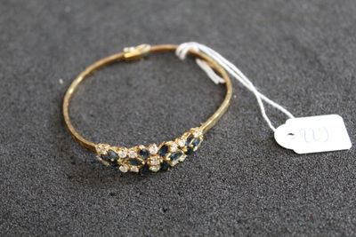 un bracelet en or orné de pierres bleues et blanches