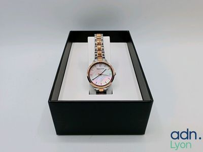 l'image d'une montre dans une boîte sur une surface blanche