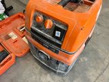 an orange machine that is sitting on the ground