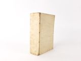 an old book sitting on top of a white table next to a white wall