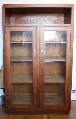 a large wooden cabinet with glass doors in a room