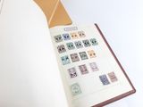 an open book with stamps on it sitting on a table