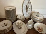 many plates and bowls on a table with a clock on the wall