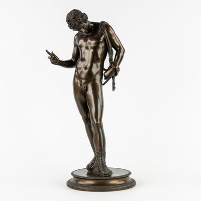 une statue en bronze représentant un homme debout sur un socle