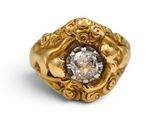 gros plan d'une bague en or avec un diamant au centre