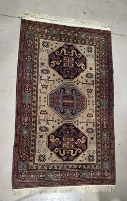 an oriental rug hanging on a wall next to a toilet