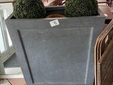 tables and chairs in a restaurant with a large planter on the floor