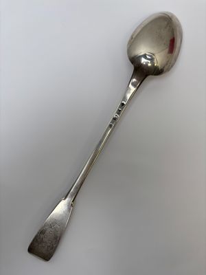 a spoon that is sitting on a white surface