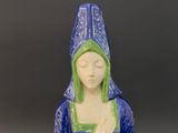 a blue and green statue of a woman holding a bowl