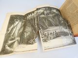 deux livres ouverts posés sur une table, sur lesquels figure un dessin