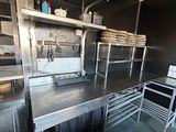 une grande cuisine avec de nombreux plans de travail en inox