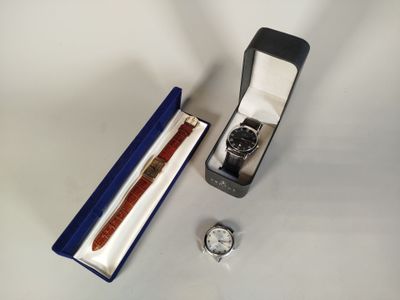 une montre et un stylo dans une boîte posée sur une table