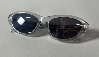 silver sunglasses with black lenses on a white surface