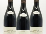 trois bouteilles de vin sont alignées sur une surface blanche