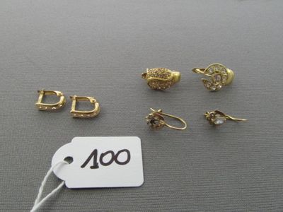 plusieurs paires de boucles d'oreilles et une étiquette de prix posées sur une table