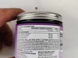 a person holding a jar of lavender body butter in their hand