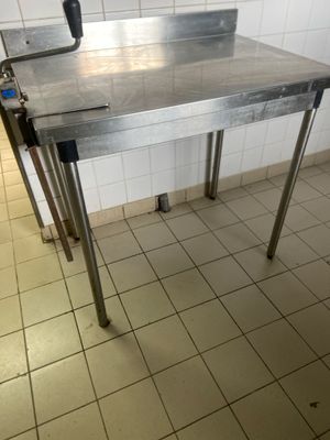 a metal table with a knife on it in a kitchen