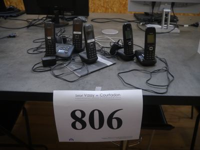 Plusieurs téléphones portables sont posés sur une table, accompagnés d'une étiquette de prix