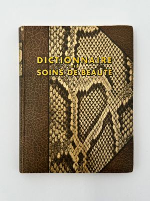 un livre dont la couverture est en peau de serpent et sur laquelle figurent des lettres dorées