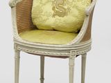 une image représentant une chaise blanche sur laquelle est posé un coussin jaune
