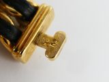 a close up picture of a gold and black bracelet