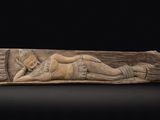 une image représentant une sculpture d'une femme allongée sur une bûche