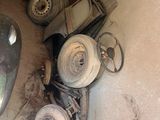 a pile of old tires and a car in a garage