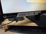 a computer monitor sitting on top of a wooden desk